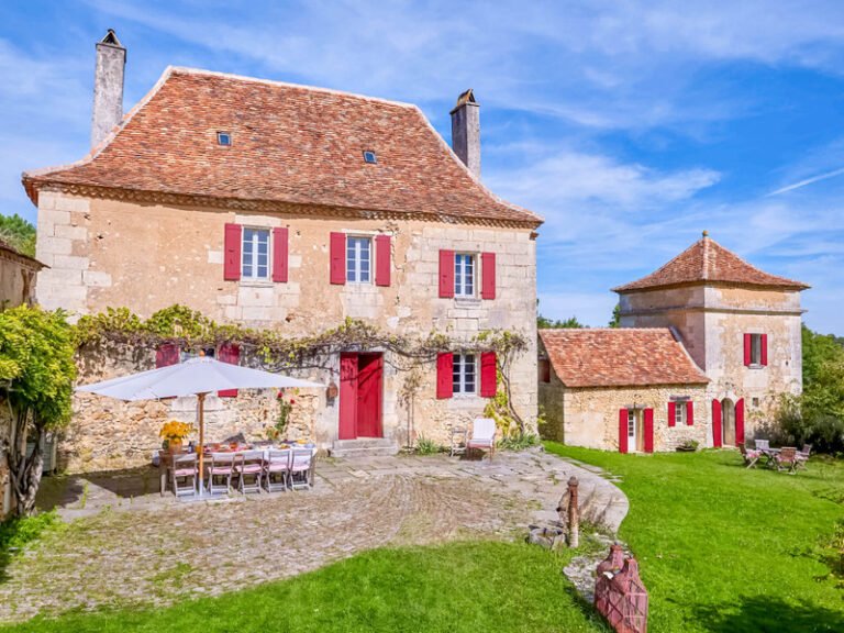 SHOKO standing before a honey-stone Périgord country house in the Dordogne